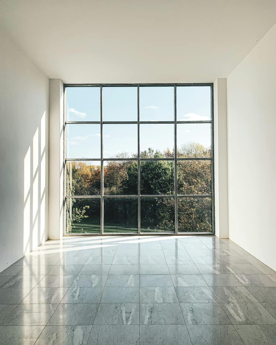 Sunlit room with a large gridded window and a stone floor